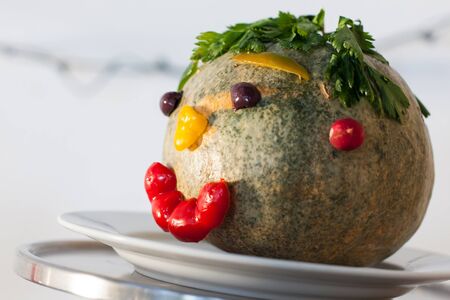A big pumpkin head with leaves as hair and a smiling face.の写真素材