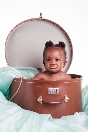 A little African girl in a hat case on a light turqoise organza.の写真素材