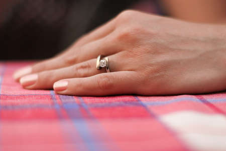 The engagement ring on the hand of a young woman.