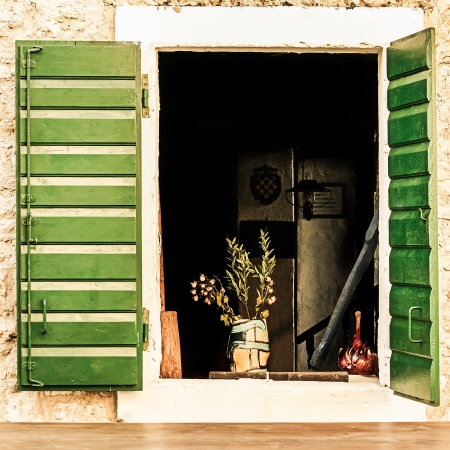 Green window shutters situated on a old home in Croatia.の写真素材
