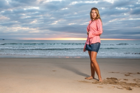 A young girl on the beach dressed in cool clothes with  pink long sleevesの写真素材