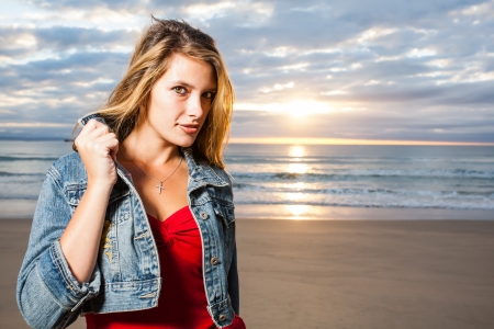 A sparkling, young girl on the beach with sunrise.の写真素材
