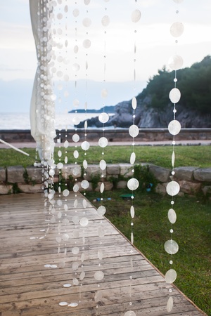 Shell strings hanging from  the roof by the ocean.の写真素材