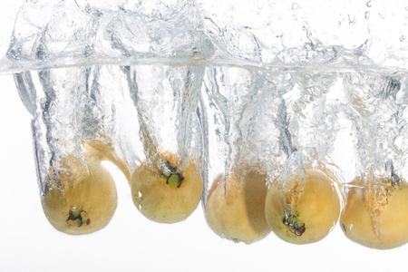 Five guavas are thrown into a bowl of water.の写真素材