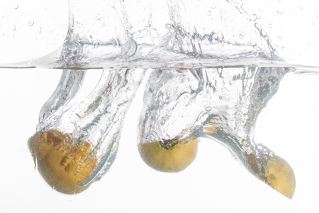 Two guavas are thrown into a bowl of water.の写真素材