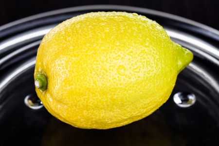 A ripe, yellow lemon on a crystal glass plate.の写真素材