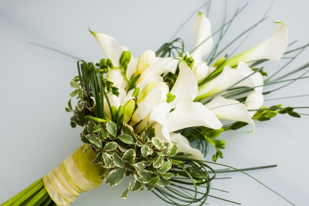 A big flower bouquet filled with cala lillies and other plants.の写真素材