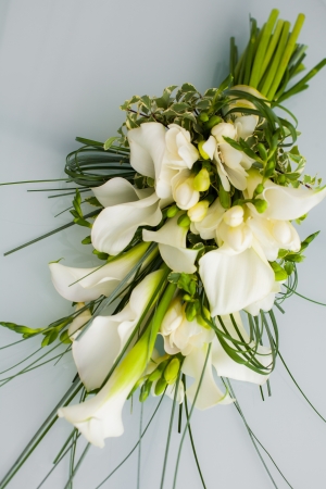 A big flower bouquet filled with cala lillies and other plants.の写真素材