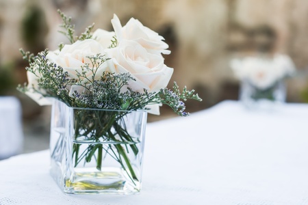 A bunch of roses in huge vase on a table with other flowr.の写真素材