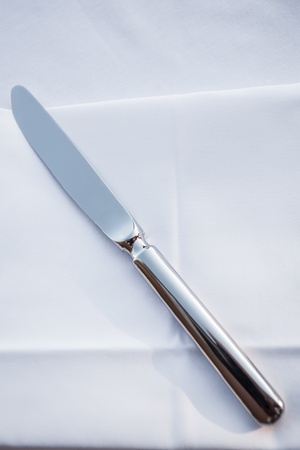 A single knife laying on a plain white serviette.の写真素材