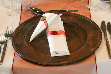 A very nicely decorated wedding table with plates and serviettes.の写真素材