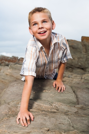 A blond little boy are being photographed on the beach.の写真素材