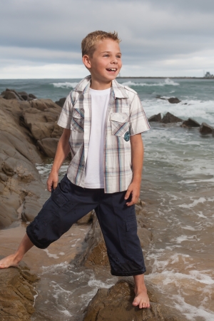 A blond little boy are being photographed on the beach.の写真素材