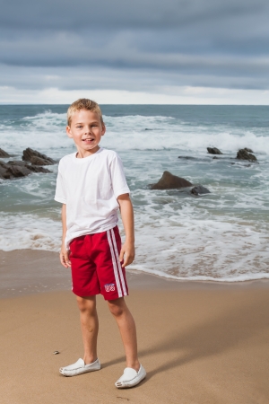 A blond little boy are being photographed on the beach.の写真素材