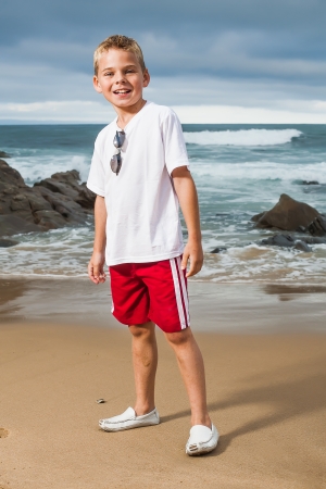 A blond little boy are being photographed on the beach.の写真素材