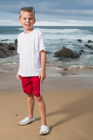 A blond little boy are being photographed on the beach.の写真素材