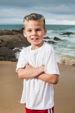 A blond little boy are being photographed on the beach.の写真素材