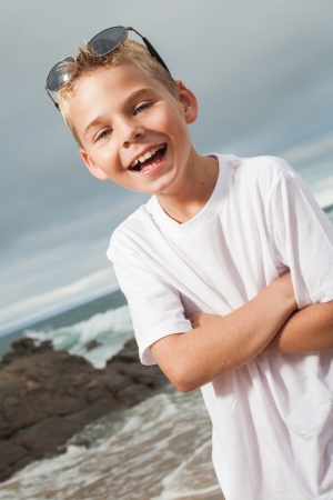 A blond little boy are being photographed on the beach.の写真素材
