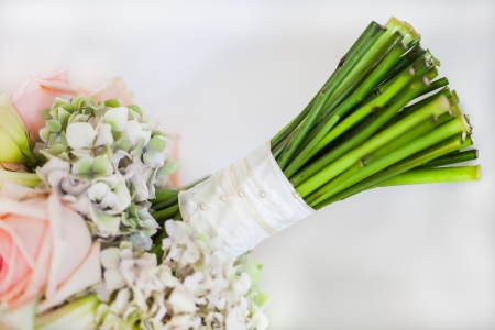 A bridal bouquet filled with light pink roses and some Christamas roses as well.の写真素材