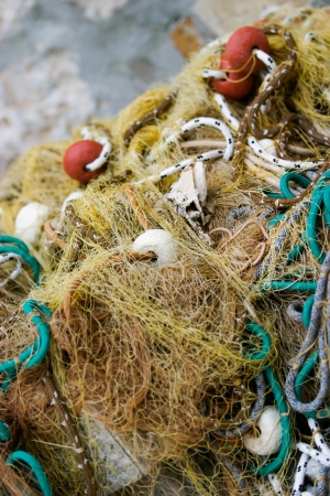 Some fish net laying in a bundle on the ground.の写真素材
