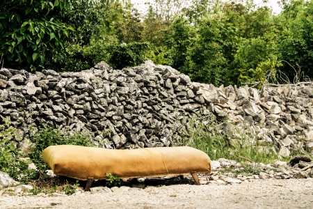 A yellow sofa standing in the sun.の写真素材