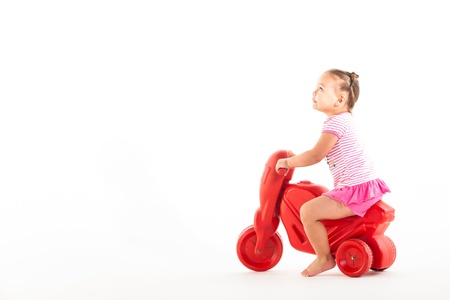 A toddler with her three wheel bike, very consernd about the condition.の写真素材
