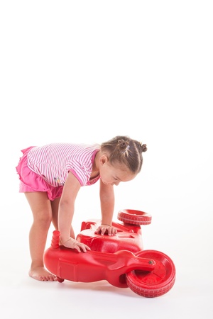 A toddler with her three wheel bike, very consernd about the condition.の写真素材