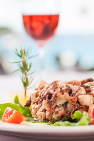 A fish dish served with salad and semi-sweet wine.の写真素材