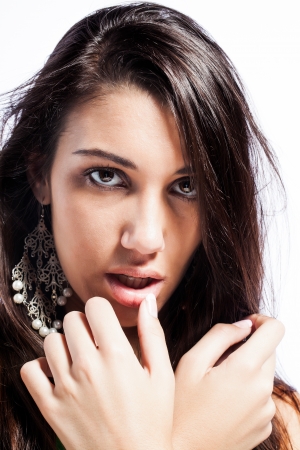 young caucasian model with brunette hair looking seductive while playing with her full lipsの写真素材