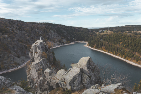 Lac Blanc from hiking trail through the vosges mountains in france. Beautiful bright blue mountain lake with statue on top of rock cliffの写真素材