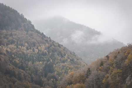 Clouds rolling through autumn mountains on dark and moody day. Vosges, Franceの写真素材