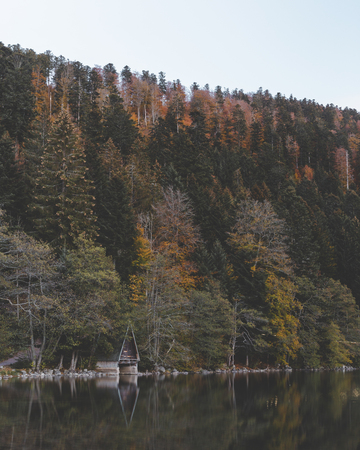 boathouse at lake in autumn forest at lac longemer-xanrupt in Vosges, Franceの写真素材