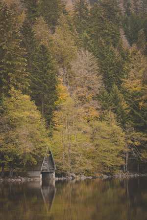 boathouse at lake in autumn forest at lac longemer-xanrupt in Vosges, Franceの写真素材
