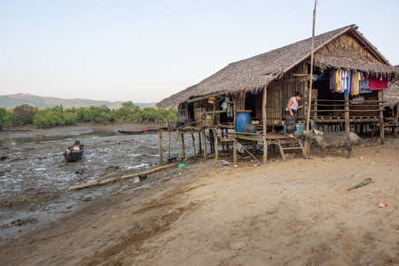 Duya/Myanmar-24.02.2017:The bamboo house, woman and her pigのeditorial素材