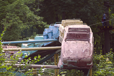 Old rusty roller coaster in an abandoned park with a hot summerの写真素材