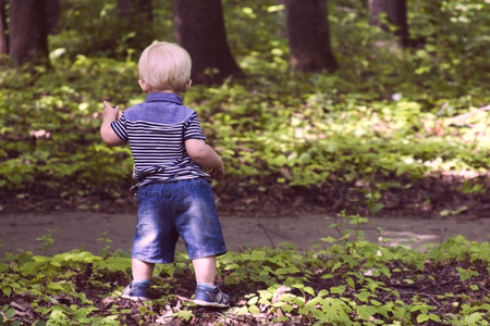 Sweet baby boy dancing in a colorful summer parkの写真素材