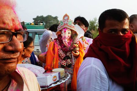 NEW DELHI, DELHI / INDIA â September 15 2016: An unidentified man is holding an idol of Hindu god Ganesh on the occasion of Ganesh Visarjan, New Delhi, India.のeditorial素材