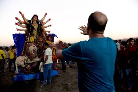 New Delhi / India â September 30 2017: An unidentified man is giving directions to a group of unidentified people around an idol of Hindu goddess Durga on the occasion of Durga Visarjan on the Yamuna River in New Delhi.のeditorial素材