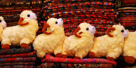 Stuffed toys  sheep  on a pile of textiles for sale
