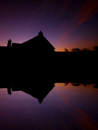 An old watermill next to a lake, taken on a long exposure just before daybreak. Star trails and...