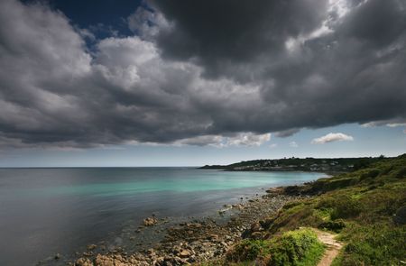 The coastal footpath which navigates its way around the United Kingdom has many spectacular sights, one of which is the sweep of the Lizard peninsula in Cornwall. The little fishing village of Coverack can be seen in the background of this image as a passの写真素材