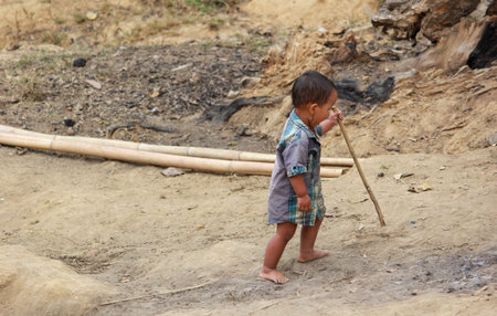 Bandarban, Bangladesh-December 15,2018: A little indigenous kid learning to walk alone by holding stickのeditorial素材