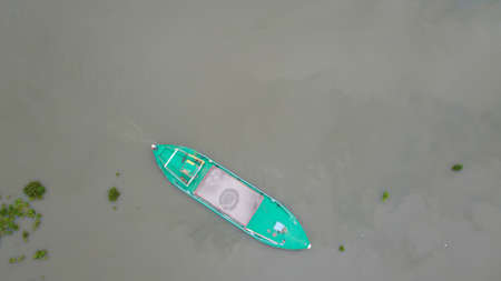 Aerial view of A Blue color steel boat carrying sands in the Buriganga river in Dhaka, Bangladesh