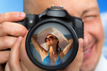 Smiling photographer capturing portrait of bikini girlの写真素材