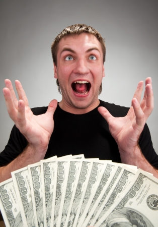 Portrait of very excited man with moneyの写真素材