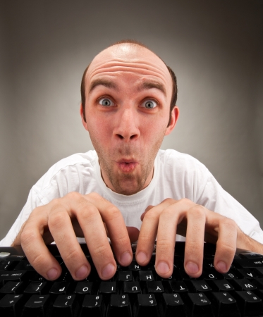 Very surprised funny nerd working on computerの写真素材