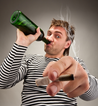 Drunk bizarre sailor with bottle and cigaretteの写真素材