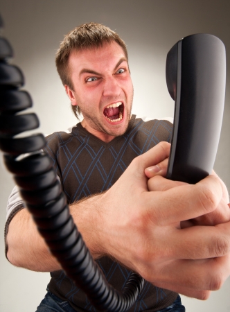 Portrait of mad office manager screaming to phoneの写真素材