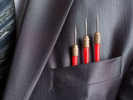 Business concept - three red darts in businessman suit pocketの写真素材