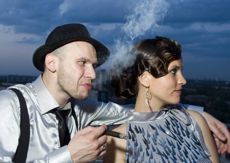 Smoking impudent gangster with retro girlの写真素材